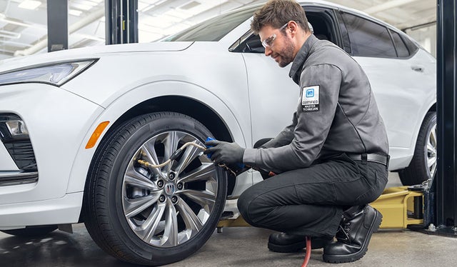 Service Technician checking the air pressure of a front tire
