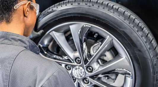 Service Technician in the process of removing a wheel