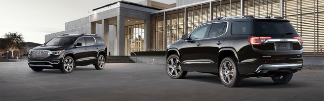 Two Acadias parked in front of a building