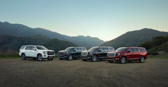 GMC Yukons parked with mountains in the distant background